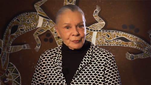 Dr Lois Peeler in front of Aboriginal artwork