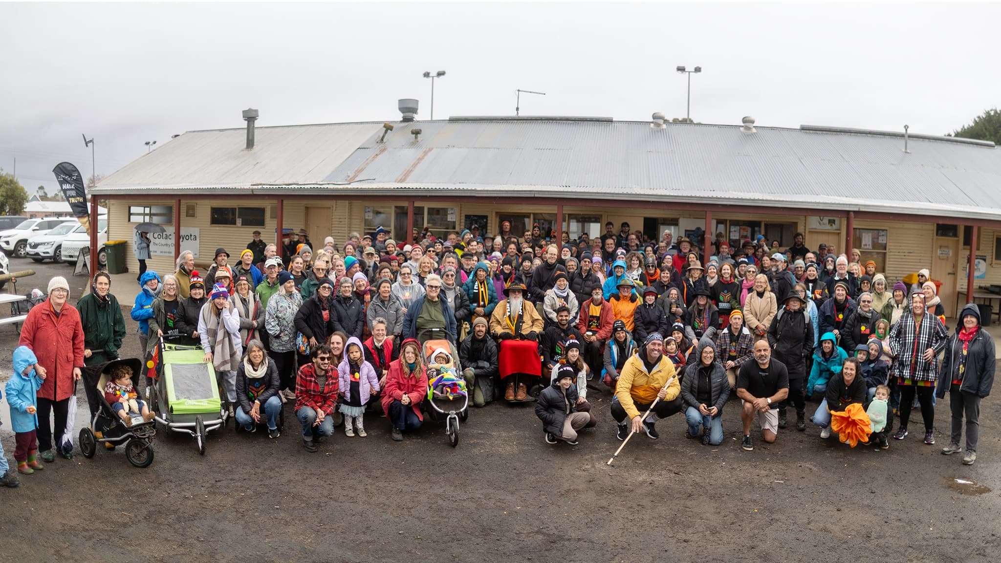 A large group of people stand and kneel in front of a building in Colac on the Walk for Truth.