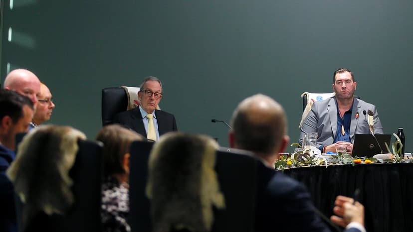Tony North and Travis Lovett look sternly towards state witnesses at a Yoorrook public hearing.