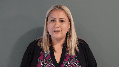 Kimberley Do, Yappera, stands indoors in front of a grey wall.