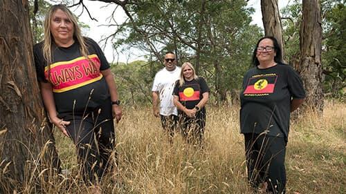Donna, Tina, Sonny and Joanne Wright stand outdoors amongst long brown grass and tall trees.
